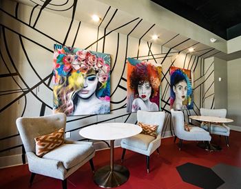 Collaboration room with art on the wall and chairs with a table in front of them at the collective noda charlotte nc.